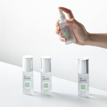 Afbeelding in Gallery-weergave laden, Hand die de BIOEFFECT Icelandic Water Mist spray vasthoudt boven drie flacons op een minimalistische witte achtergrond.
